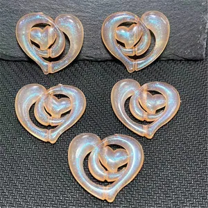 Gros plan sur les breloques DIY en résine cœur double iridescentes, parfaites pour les bijoux.