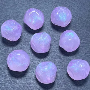 Detalle de cuentas de higo luminosas de acrílico morado para bisutería y manualidades DIY.