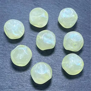 Primer plano de cuentas de acrílico translúcido luminosas para accesorios de joyería de bricolaje.