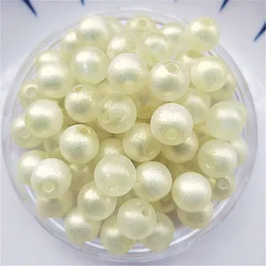 Gros plan de perles rondes en acrylique jaune clair pour la fabrication de bijoux DIY.