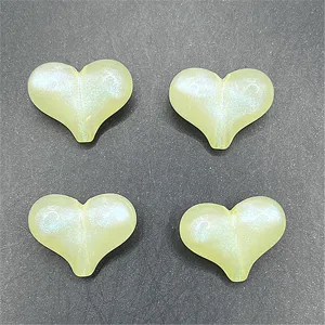 Detail shot of four luminous mermaid heart resin DIY charms for phone chains and crafts.
