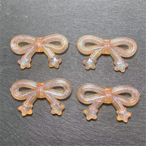 Close-up detail of translucent orange glitter star bowknot resin DIY craft bead accessories.