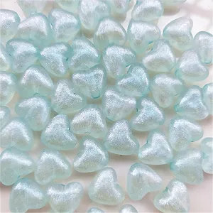 Detail view of 10mm light blue acrylic heart beads with iridescent mermaid finish for DIY crafts.