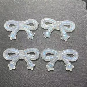 Close-up detail of iridescent translucent bow charms with star tails, perfect for DIY jewelry.