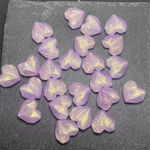 Close-up detail of purple glitter heart acrylic faceted beads for DIY handmade jewelry crafting.