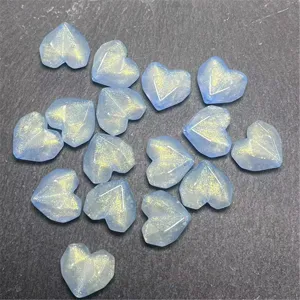 Acrylic faceted heart beads with gold glitter shimmer, detail close-up for DIY jewelry crafts.