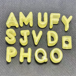 Detalle de cuentas de letras luminosas de acrílico con agujero grande para llaveros DIY.
