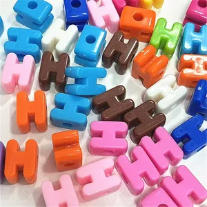 Detalle de cuentas de letras acrílicas de colores para llaveros y accesorios artesanales de bricolaje.