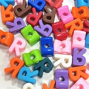 Primer plano de cuentas de letras acrílicas de colores, ideales para manualidades y joyas DIY.