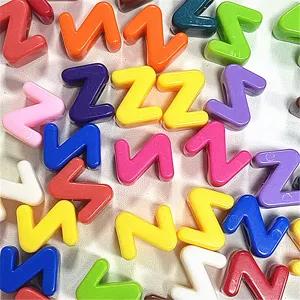 Primer plano detallado de cuentas de letras de acrílico de colores con agujeros grandes.