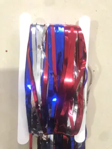 Red white blue foil fringe curtain detail, glossy metallic texture for festive party decor.