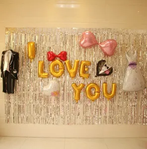 Silver tinsel fringe curtain backdrop with party foil balloons for wedding birthday party decor.