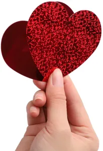 Close-up detail shot of red glitter heart pendant hanging decoration, festive holiday decor.