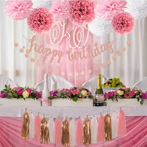 Rose gold birthday party decoration set including paper pom poms, banner and foil tassels.