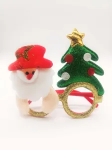 Close-up of Christmas party glasses with plush Santa Claus and glittering tree decor.