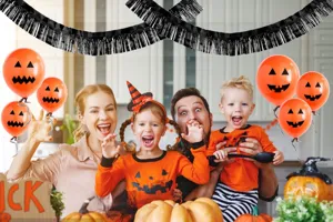 Halloween party scene detail showing black fringe tinsel banner hanging decoration setup.