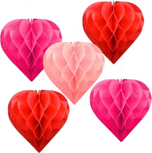 Hart honingraat papier bal detailopname, hangend decoratief ornament voor feestviering, rood en roze.