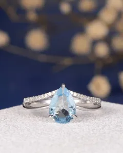 Atemberaubender birnenförmiger blauer Edelsteinring mit funkelnden Diamanten am gespaltenen Ring.