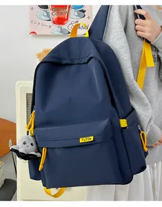 Detail view of navy blue student casual backpack with bright yellow straps and cute octopus charm.