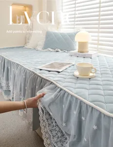 Close-up detail of blue quilted bay window cushion with elegant lace trim and soft fabric.