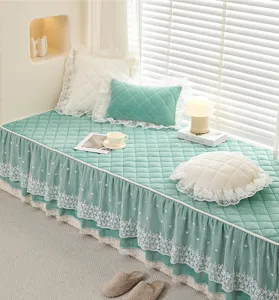 Detailed view of green quilted bay window mat featuring elegant white lace trim for home decor.