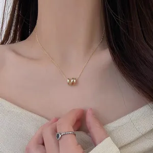 Detail view of the elegant geometric wave pendant necklace, featuring delicate gold chain.