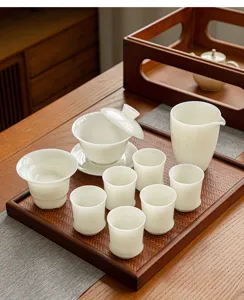 Detailed view of white ceramic kung fu tea set with gaiwan and cups on wooden tray.
