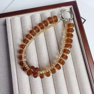 Brown crystal wheel beaded phone charm and stylish double-layer bag chain pendant for women.