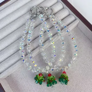Sparkling crystal beaded phone charm with cute Christmas tree pendant for festive winter style.