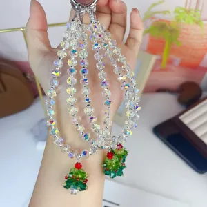 Crystal beaded phone charm with Christmas tree pendant, sparkly bag hanging ornament detail.