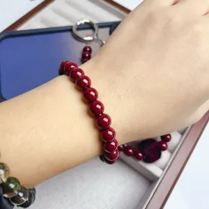 Elegant dark red beaded bracelet or phone chain charm, retro style fashion accessory for women.