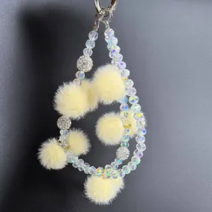 Ciondolo per telefono in perle di cristallo chic con pon pon soffici, cinturino doppio.