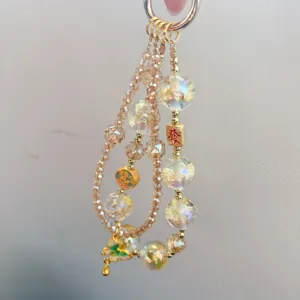 Detailed view of fashionable crystal beaded phone charm with fortune bead and alloy pendant.