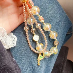 Crystal beaded phone charm detail view, colorful shiny beads and cute butterfly pendant.