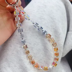 Crystal beaded wrist strap detail, colorful gradient cube beads phone charm close-up view.
