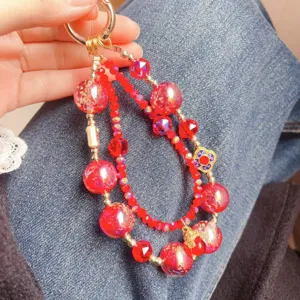 Close-up of red crystal beaded phone chain and bag charm featuring glossy beads and alloy.