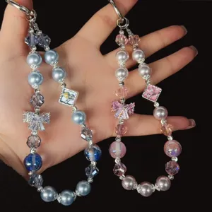 Luxury crystal beaded phone charm strap with bow zircon for stylish wrist tote accessory.