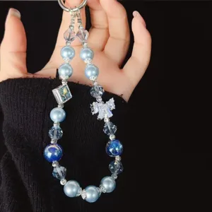 Close-up detail of the luxury blue pearl and crystal beaded phone wrist strap with cute bow.