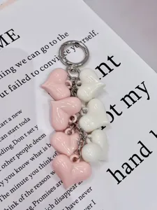 Detailed close-up of glossy pink and white resin heart charms on a sturdy metal keyring.