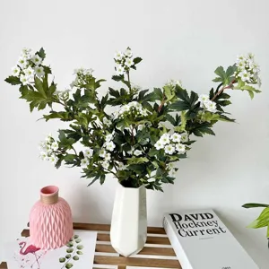 Artificial white flower bouquet in ceramic vase for home decor and wedding photography setup.