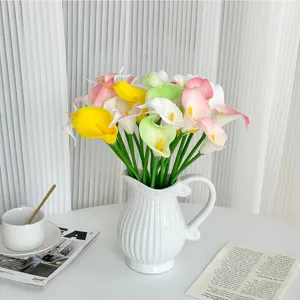 Detailansicht eines bunten künstlichen Calla-Blumenstraußes in einer weißen Keramikvase für Zuhause.