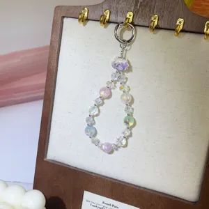 Detalle de dije de teléfono de perla de cristal, correa corta estética para mujeres.