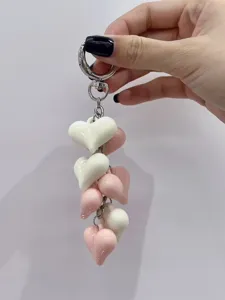 Detail view of a cute keychain with multi pink and white heart charms and silver hardware.