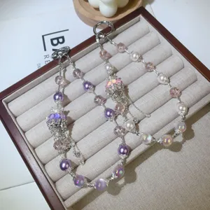 Close-up detail of luxury crystal pearl beaded phone lanyard and stylish wrist strap accessory.