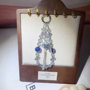 Crystal beaded phone charm pendant detail, sparkling rhinestone lotus keychain accessory.