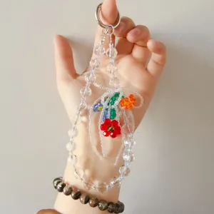Detailed close-up shot of colorful crystal beaded flower phone charm and pendant.