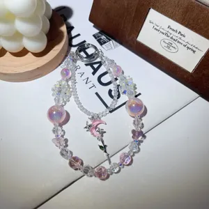 Crystal beaded phone charm detail, pink moon and butterfly pendant, shimmering cute accessories.