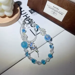 Exquisite blue crystal beaded phone charm with butterfly and moon metal pendant for cute style cases.