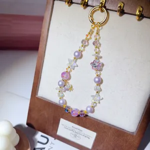 Handmade beaded phone strap with purple pearls and crystal star pendants, exquisite detail shot.