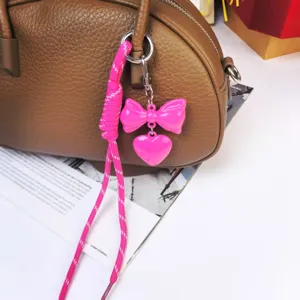 Pink bow heart keychain and braided rope bag pendant close up exquisite detail view